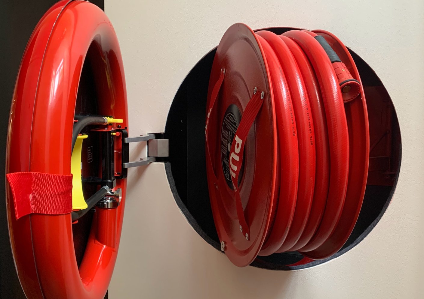Fire Hose Station recessed into the wall - mustard fabric shield in an office interior